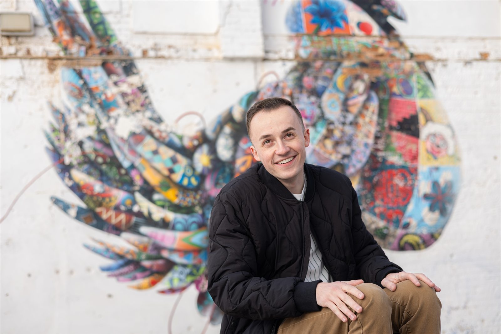 Van Taylor seated in front of a colorful mural.